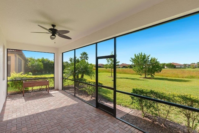 unfurnished sunroom featuring ceiling fan