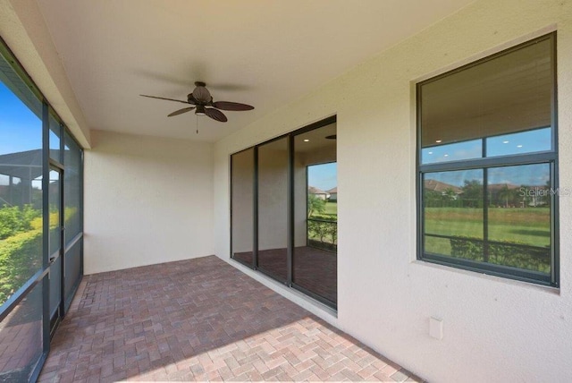 unfurnished sunroom featuring a wealth of natural light and ceiling fan