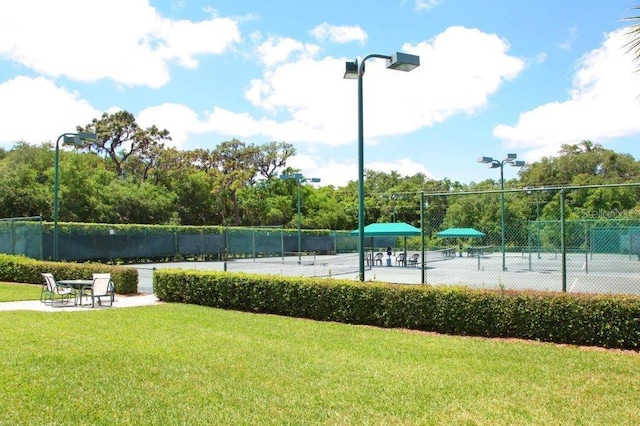 view of home's community featuring a yard and tennis court