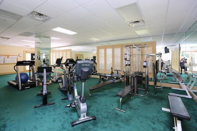 gym with a paneled ceiling and carpet floors