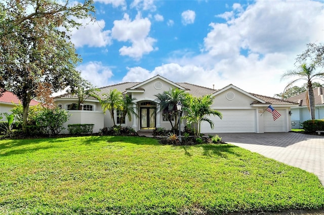 view of front of property with a front yard, a garage, and french doors