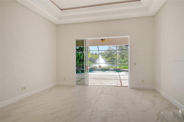 unfurnished room with ceiling fan and a tray ceiling