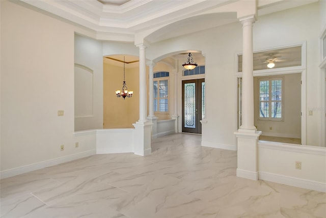 foyer entrance featuring french doors, an inviting chandelier, crown molding, and decorative columns