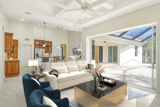 living room featuring a towering ceiling, beamed ceiling, ceiling fan, crown molding, and coffered ceiling