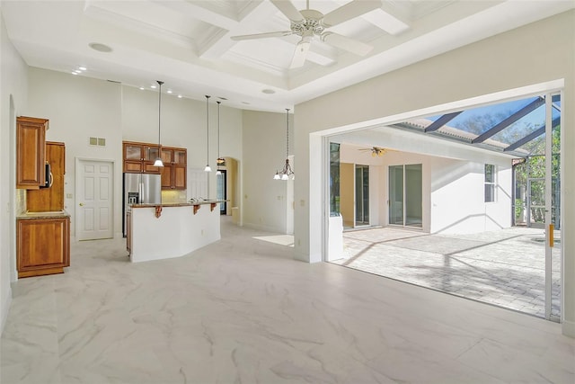 unfurnished living room with beam ceiling, a high ceiling, ceiling fan, crown molding, and coffered ceiling