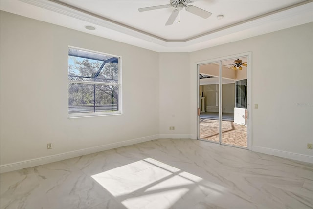 unfurnished room featuring ceiling fan, ornamental molding, and a raised ceiling