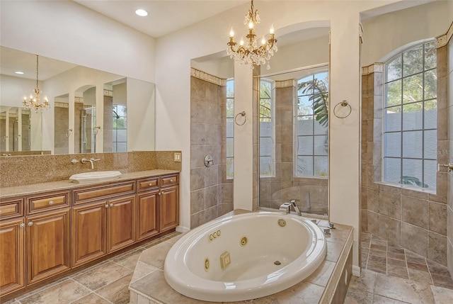 bathroom featuring vanity, an inviting chandelier, and shower with separate bathtub