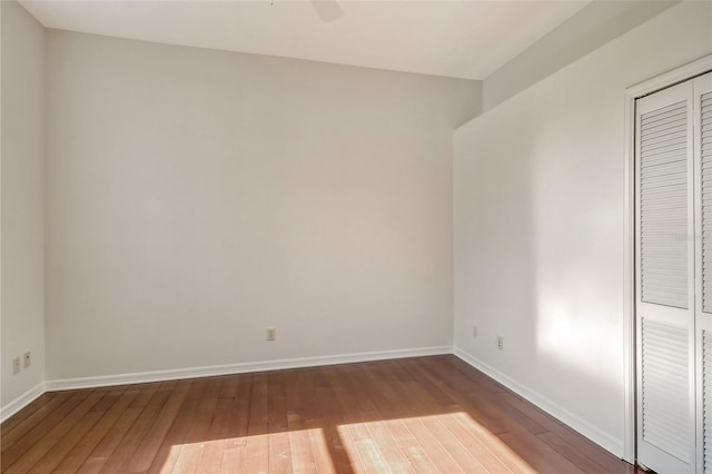 unfurnished bedroom featuring ceiling fan, a closet, and hardwood / wood-style flooring