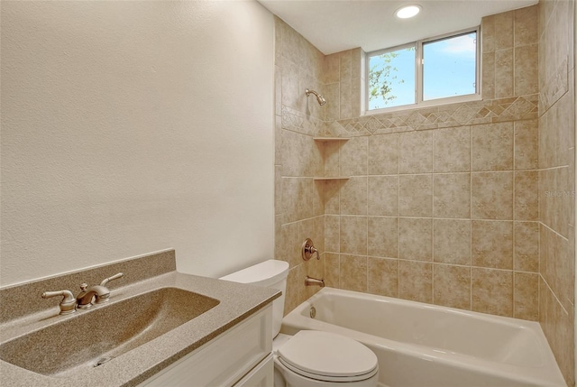 full bathroom featuring toilet, tiled shower / bath combo, and vanity