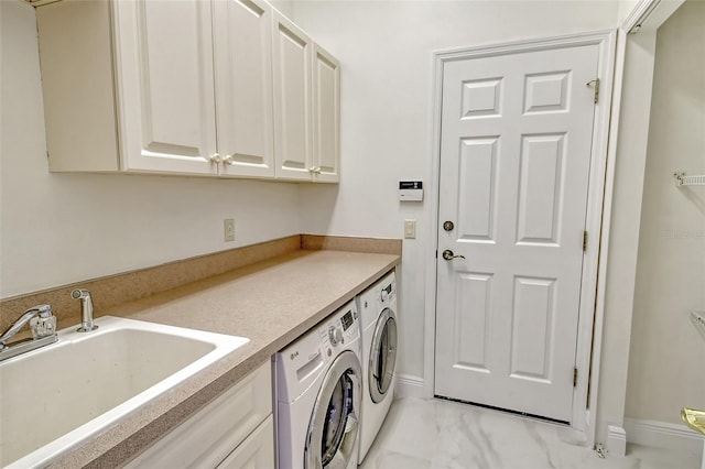 laundry area featuring sink, washing machine and clothes dryer, and cabinets