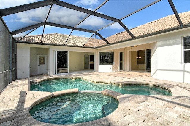 view of pool with ceiling fan, a patio area, glass enclosure, and an in ground hot tub