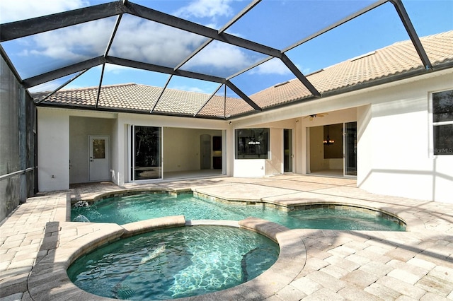 view of swimming pool with a lanai, ceiling fan, a patio area, and an in ground hot tub