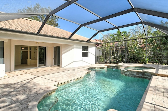 view of pool with an in ground hot tub, glass enclosure, and a patio