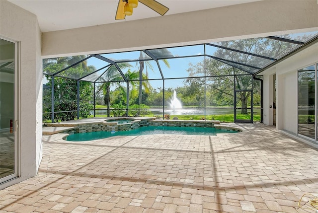 view of pool with an in ground hot tub, a patio area, and glass enclosure