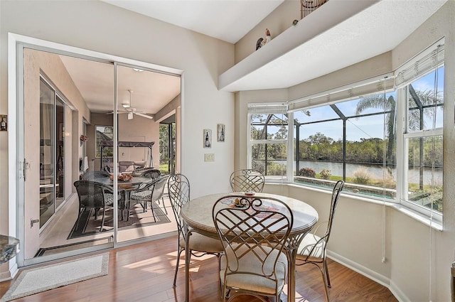 sunroom / solarium featuring ceiling fan, plenty of natural light, and a water view