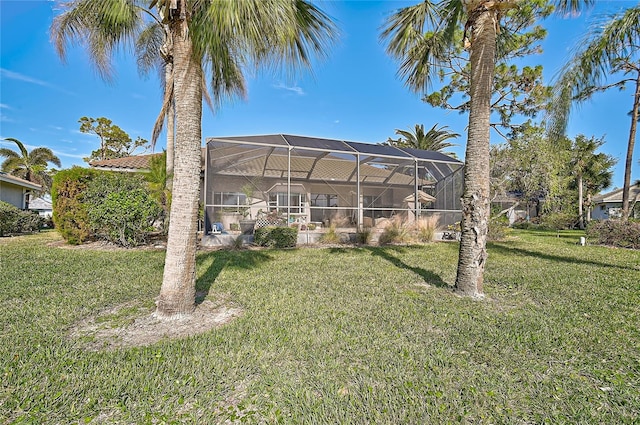 back of house with a lanai and a lawn