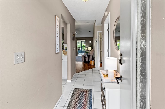 corridor featuring light hardwood / wood-style floors and a textured ceiling