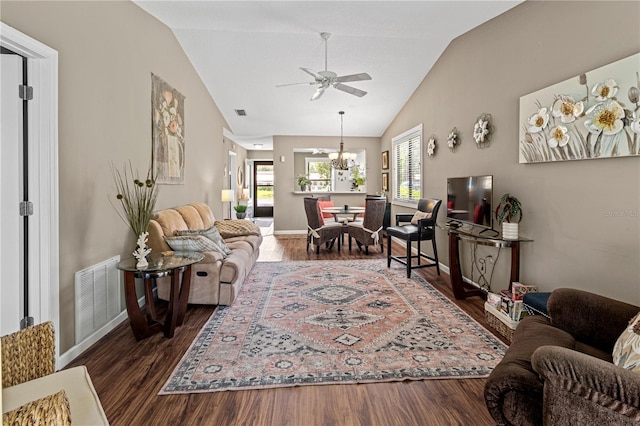 living room with ceiling fan with notable chandelier, dark hardwood / wood-style flooring, and lofted ceiling