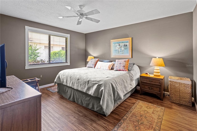 bedroom featuring ceiling fan, wood-type flooring, and a textured ceiling