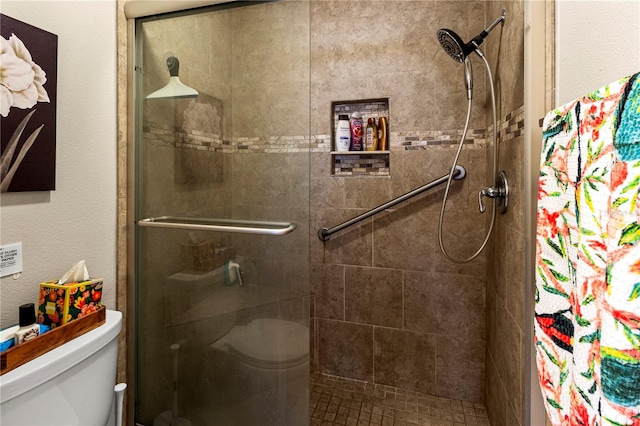 bathroom featuring tiled shower and toilet