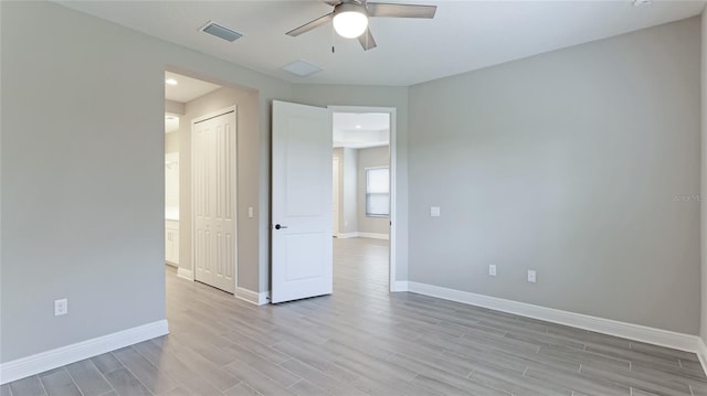 empty room with ceiling fan and light hardwood / wood-style floors