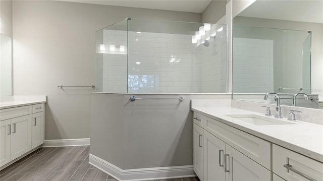 bathroom featuring hardwood / wood-style floors, vanity, and a tile shower