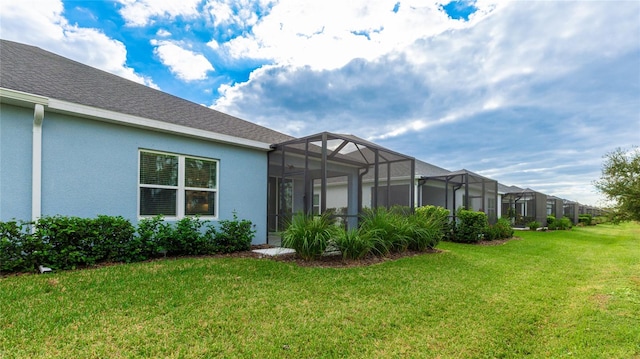 exterior space with a lanai and a lawn