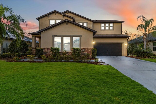 13148 Bliss Loop, Bradenton, FL 34211 - view of front facade with a garage, driveway, stone siding, and a yard