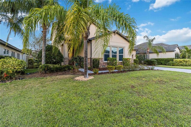 13148 Bliss Loop, Bradenton, FL 34211 - view of front of property with stone siding, stucco siding, and a front lawn