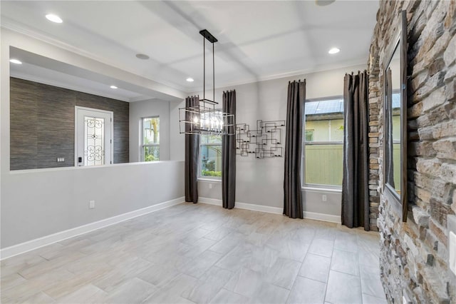 unfurnished dining area featuring ornamental molding and an inviting chandelier