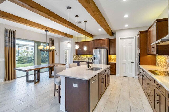 13148 Bliss Loop, Bradenton, FL 34211 - kitchen featuring stainless steel appliances, a sink, a breakfast bar area, tasteful backsplash, and beam ceiling
