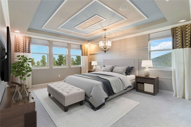 carpeted bedroom with a tray ceiling and a chandelier