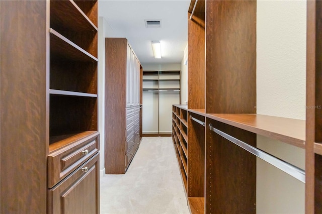 walk in closet featuring light carpet