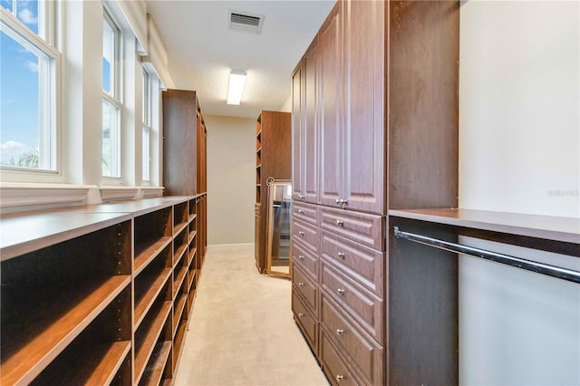 walk in closet featuring light colored carpet