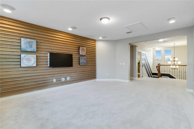 unfurnished living room with carpet and an inviting chandelier