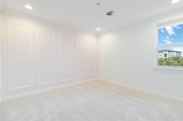 spare room featuring light colored carpet and ornamental molding