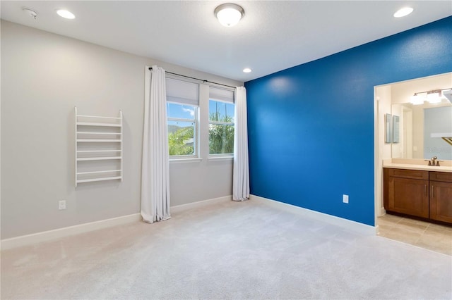 13148 Bliss Loop, Bradenton, FL 34211 - unfurnished bedroom featuring light carpet, a sink, baseboards, ensuite bathroom, and recessed lighting