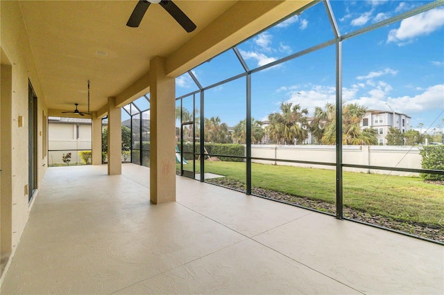 unfurnished sunroom featuring ceiling fan