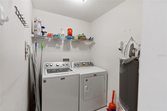 laundry room with a textured ceiling and independent washer and dryer