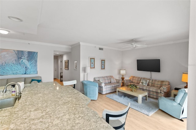 living room with hardwood / wood-style flooring, ceiling fan, ornamental molding, and sink