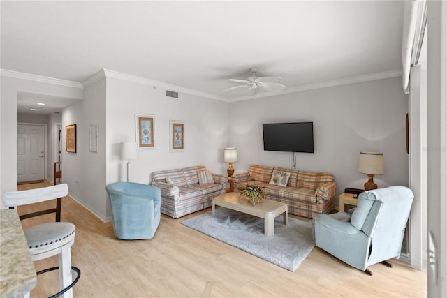 living room with light hardwood / wood-style floors, ceiling fan, and ornamental molding