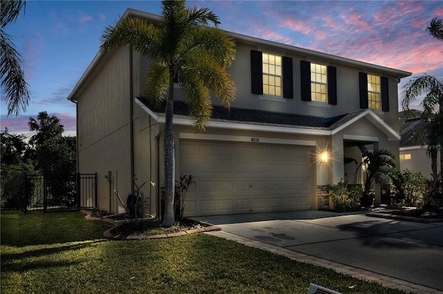 view of front of property with a garage and a lawn