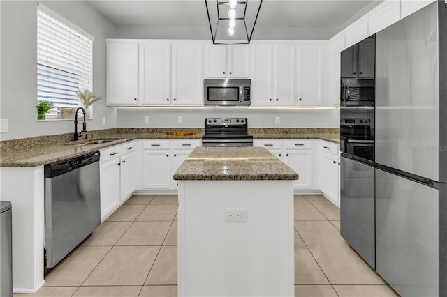 kitchen featuring a kitchen island, dark stone countertops, white cabinetry, and appliances with stainless steel finishes