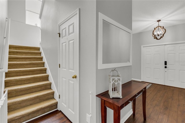 foyer entrance featuring dark wood-type flooring and a chandelier