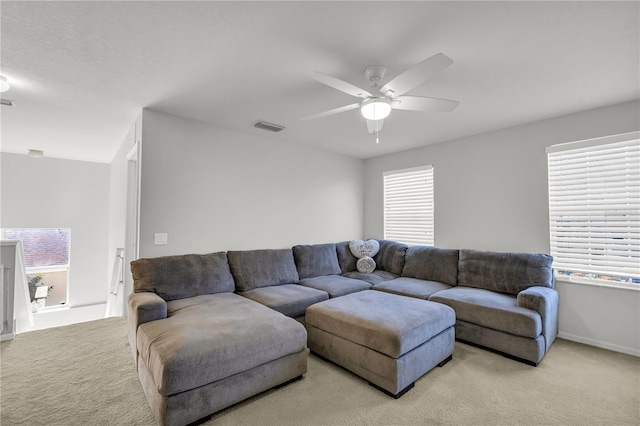 living room with ceiling fan, a healthy amount of sunlight, and light colored carpet