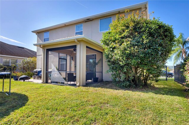 rear view of property featuring a lawn and a sunroom