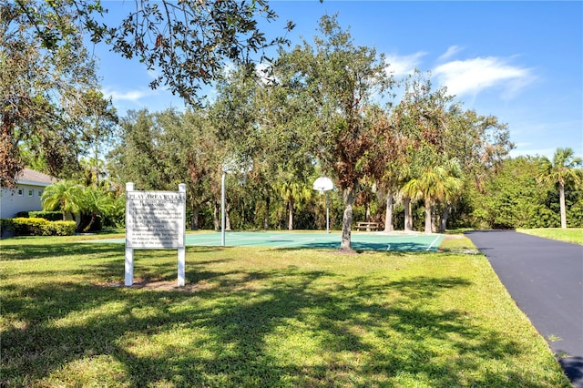 surrounding community featuring a yard and basketball court