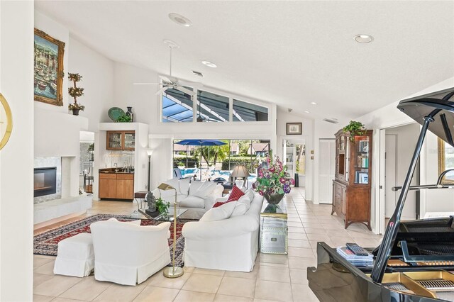 tiled living room featuring high vaulted ceiling, ceiling fan, a healthy amount of sunlight, and a premium fireplace