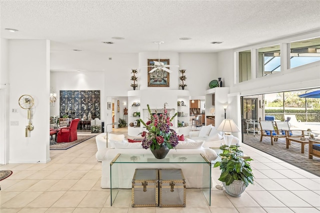 living room featuring light tile patterned floors, a textured ceiling, and ceiling fan