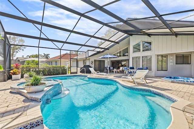 view of swimming pool with pool water feature, a patio, and glass enclosure